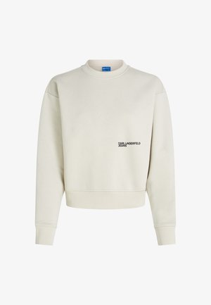 Maglione crema con polsini e orlo a coste, caratterizzato da un piccolo logo nero "KARL LAGERFELD JEANS" sulla parte sinistra del petto.