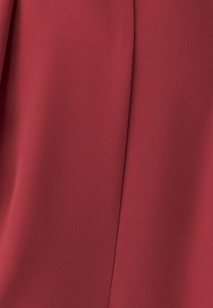 Red fabric with a smooth texture and slight sheen. Features subtle folds and a structured design, creating a clean, elegant appearance.