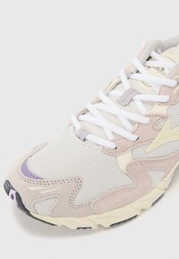 Scarpa da corsa leggera in crema, beige e lavanda, con texture in rete e suede, suola in gomma robusta e lacci bianchi.