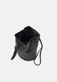 Musta nahkainen säkylaukku, jossa on teksturoitu pinta, avoin yläosa, säädettävät hihnat ja sisäinen vetoketjutasku.