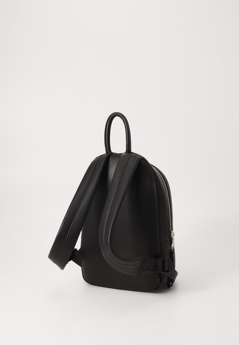 Črna usnjena nahrbtnik z zaobljeno zasnovo, ravnimi naramnicami in zgornjim ročajem. Ima srebrno zadrgo na eni strani za dostop in zapiranje.