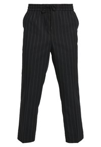 Zwarte broek met dunne verticale grijze strepen, elastische tailleband en trekkoordsluiting, weergegeven tegen een witte achtergrond.