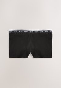 Mustat miesten bokserit, joissa joustava vyötärönauha ja valkoisella toistuva "NEXT"-teksti mustalla pohjalla.