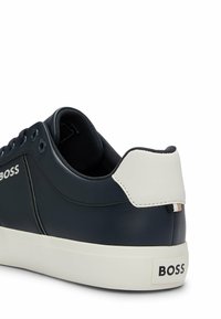 Sneaker in pelle blu con cappuccio bianco sul tallone, fodera in tessuto, punta tonda e suola in gomma. Presenta il marchio sui lati e sul retro.