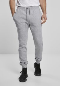 Grå sweatpants i mjukt material, med elastiskt midjeband och dragsko, sidofickor och smala mudd vid anklarna.