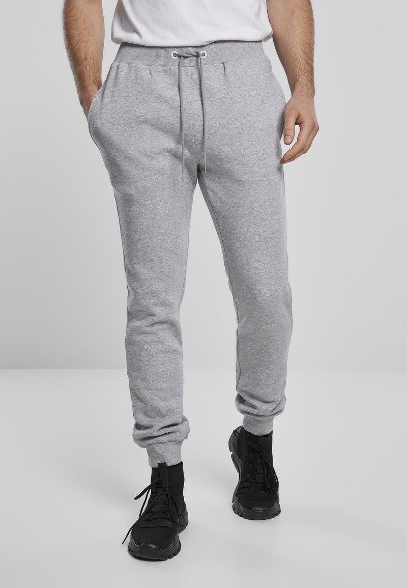 Grå sweatpants i mjukt material, med elastiskt midjeband och dragsko, sidofickor och smala mudd vid anklarna.