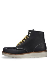 Stivali in pelle nera con lacci gialli, cucitura bianca, punta arrotondata e suola in gomma beige. Logo impresso di lato.