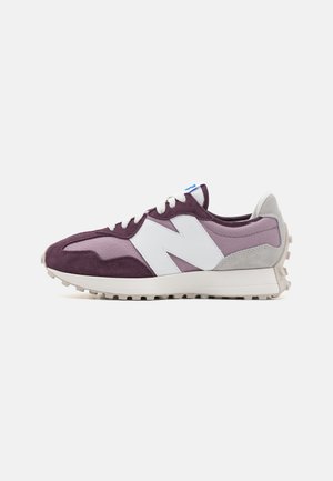 Lilla og grå sneaker med hvidt "N"-logo, hvide snørebånd, tekstureret sål og lavt snit.
