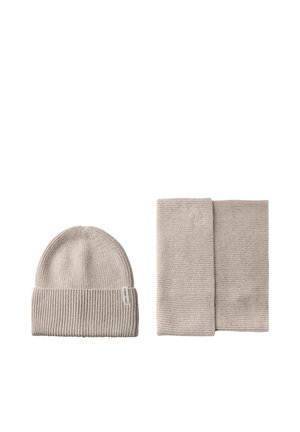 Hellbeige gestrickte Mütze mit Rippstruktur und passendem Rippenschal, beide mit einem schlichten Design und ohne zusätzliche Akzente.