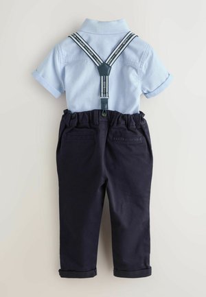 Világoskék rövid ujjú póló texturált mintával, sötétkék, gumis derekú nadrággal és állítható tartópántokkal párosítva.