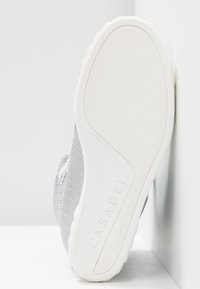 Semelle d’une basket blanche Casadei avec une accroche texturée, montrant l’embossage "Casadei" et "Made in Italy" sur la semelle extérieure en caoutchouc.