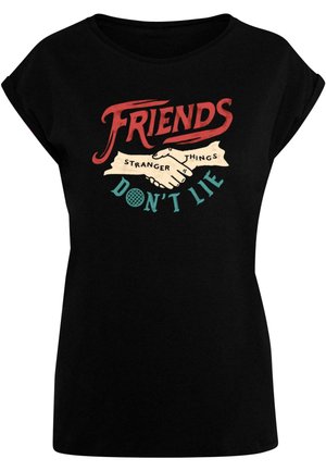 Juodas marškinėliai trumpomis rankovėmis su grafiniu piešiniu, vaizduojančiu dvi rankas, bespaudžiančias viena kitą. Tekste yra žodžiai "DRAUGAI", "KREIVI DALYKAIS" ir "NE MELUOK".