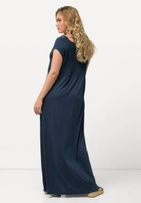 Maxime sininen mekko, jossa on teksturoitu smokkikuvioitu yläosa ja virtaava alaosa. Mekossa on lyhyet hihat ja rento leikkaus, ja se on valmistettu pehmeästä kankaasta.