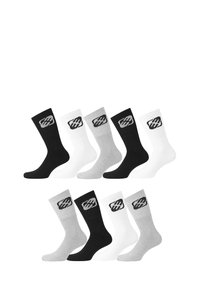 Cinq paires de chaussettes de cabine noires, blanches et grises avec un logo stylisé sur le dessus, disposées en deux rangées sur un fond blanc.