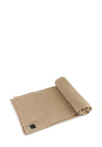 Beige vævet tekstil rullet op, med en tekstureret overflade. Har et sort mærke med logo i det ene hjørne. Blødt og smidigt materiale.
