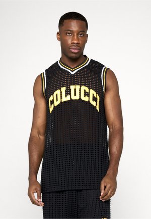 Uomo che indossa una canottiera sportiva nera in rete senza maniche con la scritta gialla "COLUCCI", in piedi davanti a uno sfondo bianco uniforme.