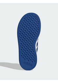 Semelle de chaussure en caoutchouc bleu avec un motif en nid d'abeille, avec des accents blancs et le logo Adidas. Texture lisse et bords arrondis.