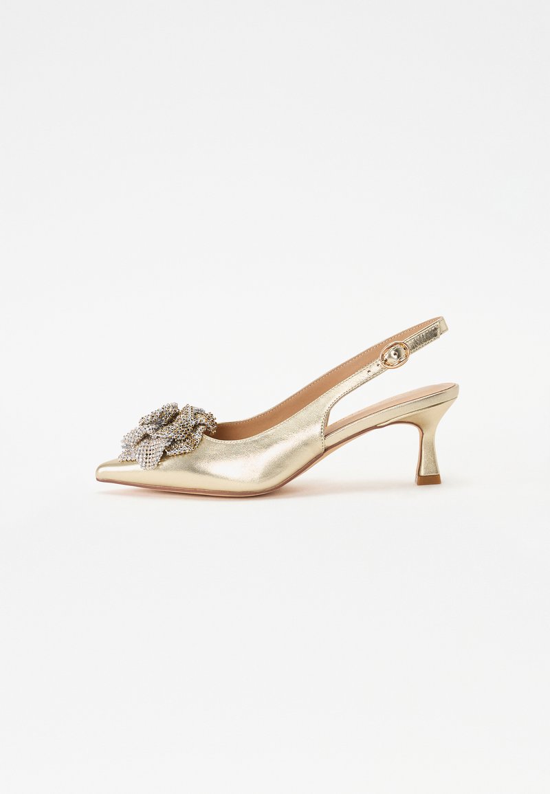 Zapato slingback dorado con punta afilada, adornado con una flor de cristal decorativa y un tacón moderado para mayor estabilidad.