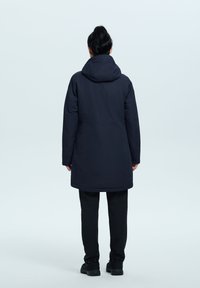 Parka impermeabile blu navy con cappuccio, design di lunghezza media, texture liscia e taglio dritto. Presenta tasche nascoste e orlo regolabile.