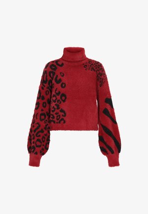 Punainen pörröinen neulepaita korkealla kauluksella, jossa on mustia leopardi- ja abstrakteja kuvioita hihoissa ja vartalossa.