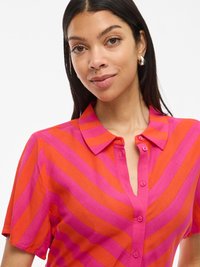 Lühikeste varrukatega särk, millel on erksad horisontaalsed triibud oranžis ja fuksiaroosas, nööpidega ees ja kraegga. Sile kangast tekstuur.