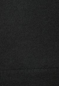 Schwarzer gestrickter Stoff mit einem strukturierten, gerippten Muster, einer glatten Oberfläche und einer einheitlichen Farbe. Die Ränder zeigen einen einfachen Saum.