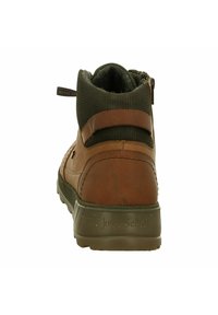 Bottines en cuir marron et textile vert, avec une finition texturée, dotées d'un col rembourré et d'une marque distinctive sur le talon.