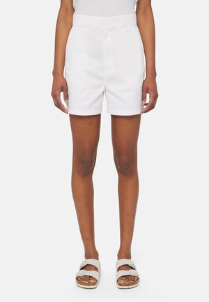 Pantaloni corti bianchi in cotone con vita alta, parte anteriore piatta e tasche. Texture morbida e vestibilità su misura, abbinati a sandali di colore chiaro.