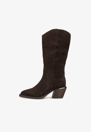 Botte en daim marron hauteur genou avec un bout pointu et un talon épais bicolore. Texture lisse avec des coutures latérales et sans matériel visible.