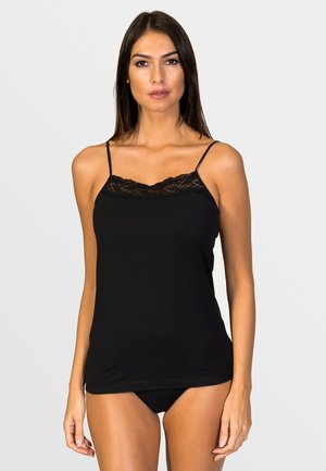 Camiseta de tirantes negra con detalle de encaje, tirantes finos ajustables, textura suave, diseño ajustado y corte a media longitud, combinada con pantalones negros a juego.