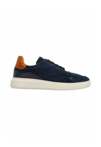 Navyblauwe suède sneaker met een lichtbruin leren hielaccent, witte rubberen zool, ronde vorm en zwarte vetersluiting.