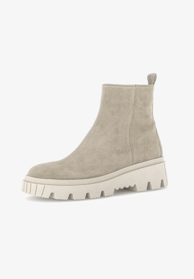 Bottine en daim beige avec semelle blanche épaisse et rainurée, équipée d'une languette à l'arrière, vue de profil sur fond blanc.