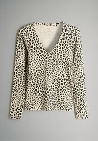 Maglietta a maniche lunghe di colore crema con stampa leopardata nera, con scollatura a V e tessuto testurizzato. Esposizione in piano, senza hardware visibile.