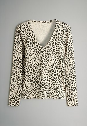 T-shirt à manches longues en crème avec un imprimé léopard noir, présentant un design à col en V et un tissu texturé. Présentation à plat, sans matériel visible.