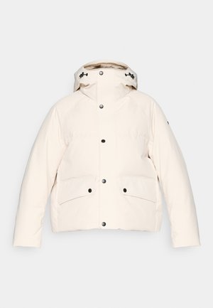 Kreminės spalvos pūkuotas švarkas pagamintas iš lygios medžiagos. Jame yra aukštas apykaklė, reguliuojama kapa, didelės priekinės kišenės ir juodi užsegimai.