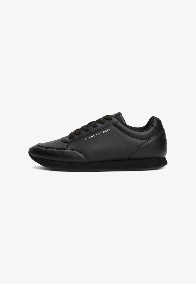 Baskets en cuir noires Tommy Hilfiger avec fermeture à lacets et semelle basse profilée, nom de la marque et logo sur le côté.