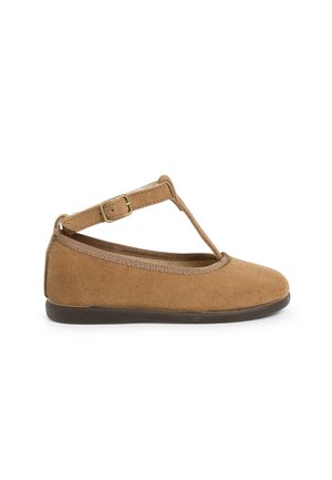 Chaussure plate en daim marron avec un design à sangle en T, bout rond, détails élastiques et une petite boucle ajustable sur le côté. Semelle plate.