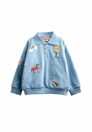 Lyseblå langærmet polo med træknapper og farverige patches, herunder en hest, regnbue, stjerneskud og et "Super Star" badge.