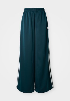 Teal brede sweatpants med elastisk talje, der har tre hvide striber langs siderne og et Adidas-logo på venstre side.