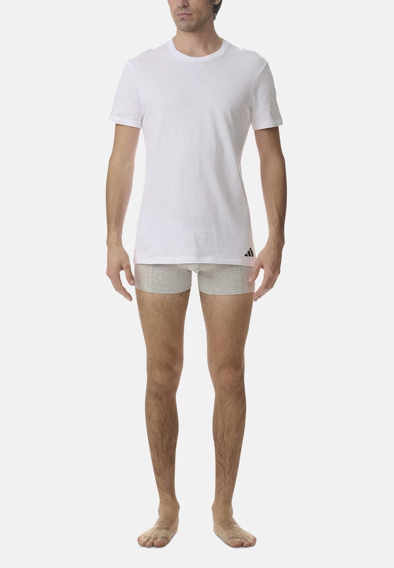 White cotton t-shirt paired with gray boxer shorts. The t-shirt is short-sleeved, while the shorts have a smooth texture and fit close to the body.