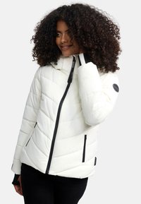 White puffer jacket with chevron quilting, black zippers, and a hood. Features a black logo patch on the sleeve and contrasting cuffs.