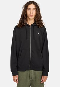 Felpa nera con zip realizzata in tessuto morbido, con tasca frontale, cappuccio regolabile con lacci e un piccolo logo sul petto.