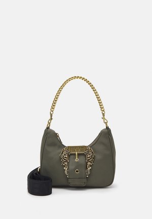 Petit sac à main vert olive avec poignée chaîne dorée, détails floraux décoratifs en or, plaque "Versace Jeans Couture" et bandoulière noire amovible.