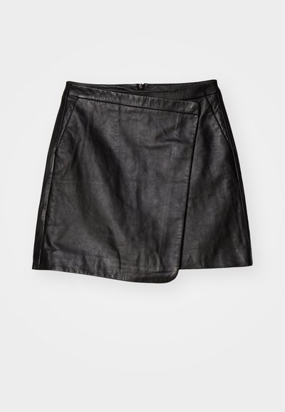 Juodas odinis mini sijonas su asimetriniu apvyniojimo dizainu, turintis lygų paviršių ir užsegimą nugarinėje dalyje.