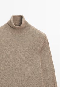 Beżowy sweter z golfem wykonany z miękkiego materiału dzianinowego. Posiada wysoki kołnierz i długie rękawy. Prosty, czysty design z prążkowanymi akcentami.