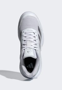 Biela športová obuv s hornou časťou z oka, polstrovaným jazykom a tromi kontrastnými sivými pruhmi. Gumená podrážka s textúrou vzoru dezénu.