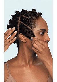 Persoon met kort, textuurhaar gestyled in bantu knopen, met haar aan één kant zichtbaar. Huidtint is diep bruin tegen een lichtblauwe achtergrond.