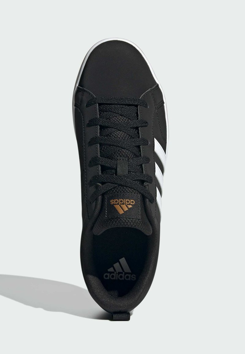 Schwarzer Sportschuh mit einer synthetischen Oberseite, ausgestattet mit weißen Streifen, strukturierten Schnürsenkeln und goldfarbenem Logo auf der Zunge. Geschlossene Zehenpartie.