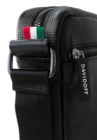 Zwarte getextureerde tas met een zilveren rits, zwarte schouderband en een klein accent van de Italiaanse vlag. Bevat een DAVIDOFF merklabel.