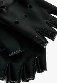 Mănuși din piele neagră fără degete, cu perforații, suprafață texturată și design cu vârful degetelor tăiat. Accentele includ cusături decorative.